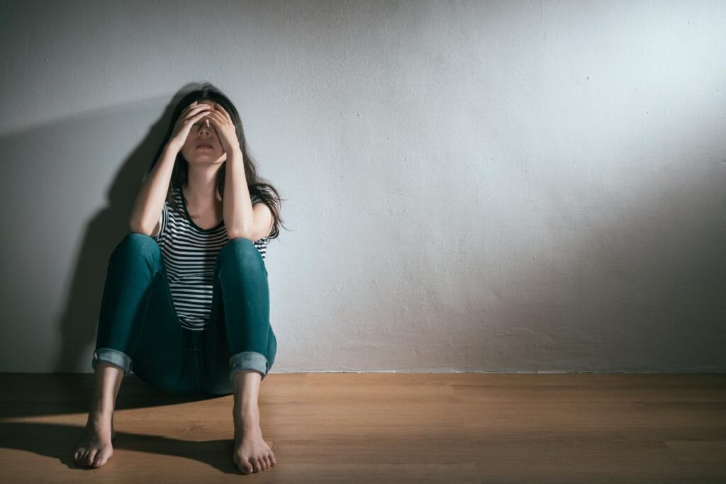 a teen holds their head while on the floor possibly addicted to adhd meds