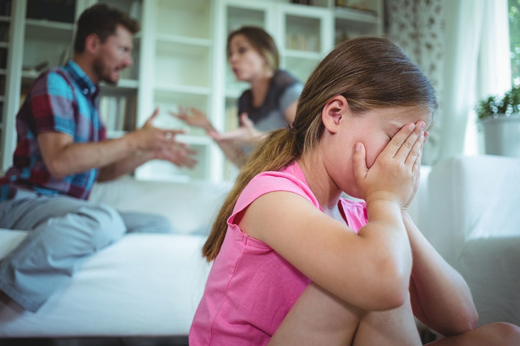 A little girl cries as her parents argue about emotional trauma common in children