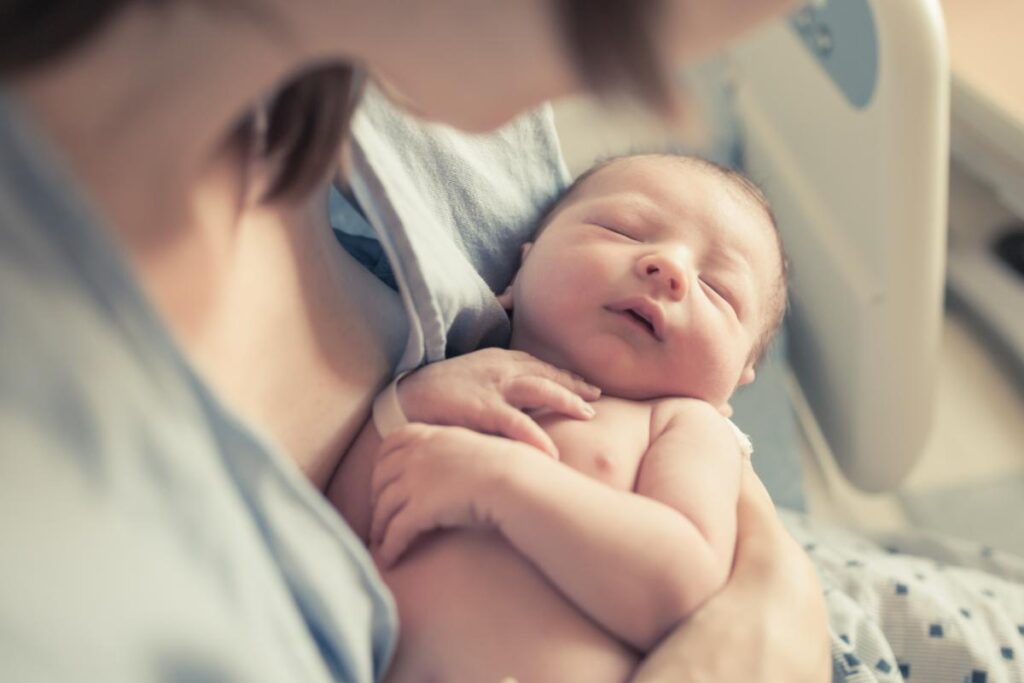 Person holding their baby while thinking about their opioid use after C-section surgery
