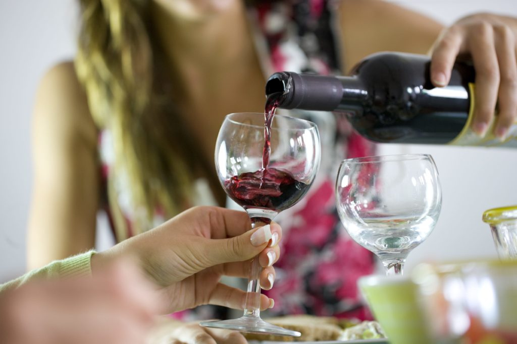 woman pouring wine and underestimating alcohol consumption
