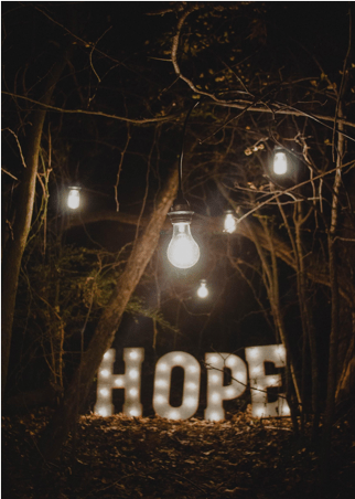lights in the dark woods spell out hope for national recovery month