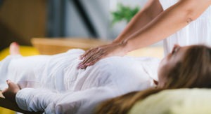 woman receives massage during holistic therapy program