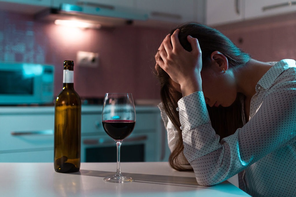 woman ponders is addiction a disease while struggling with alcohol