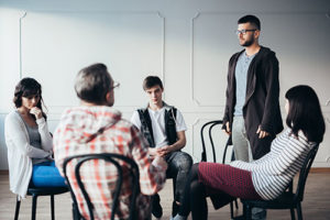 young adult addiction treatment program in group session at right step man speaking to group