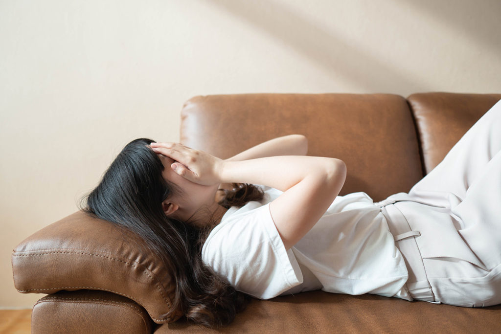 a woman frustrated on a couch thinking of mental illness statistics