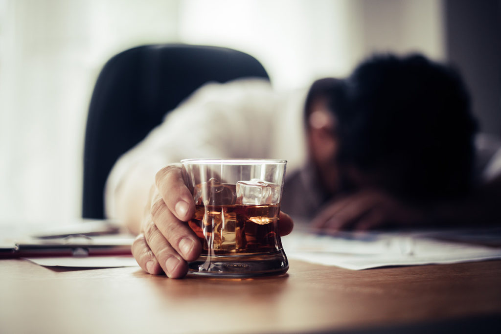 a man passed out with a glass showing physical dependence