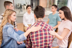 a group comforting a man at a texas drug rehab