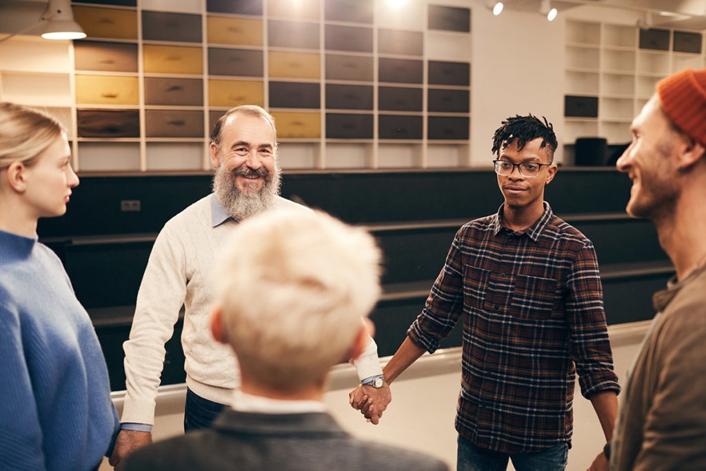 the 12 step program for addiction, patients in a circle smiling and holding hands