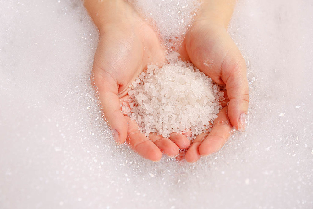 a woman holds bubble bath salts and wonders if bath salt drugs are really bath salts