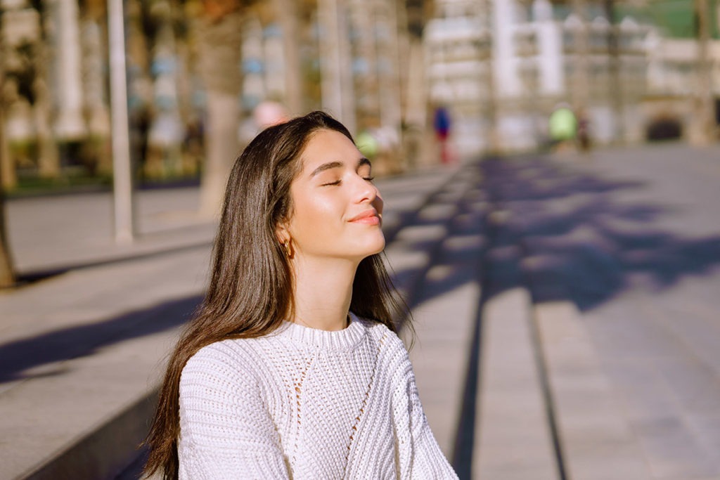 a woman breathes deeply as she remembers how to prevent a panic attack