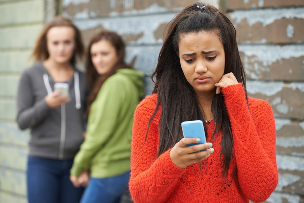 a teen girl uses her phone research to connections between social media teens and substance abuse