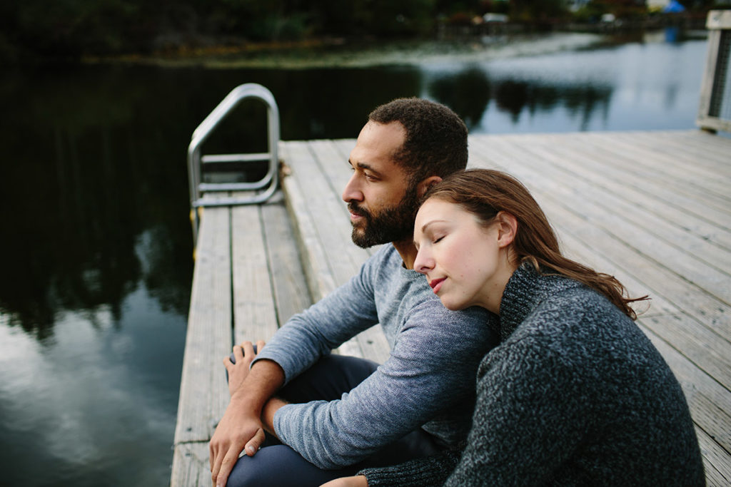 a man and woman sit on a dock as they wonder how to help an addict