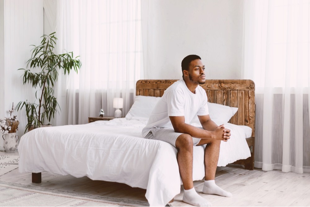 Man sitting in bed wondering what to expect when you detox