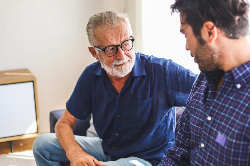 older male therapist talking to younger man explaining how to deal with a drug addicted son or daughter