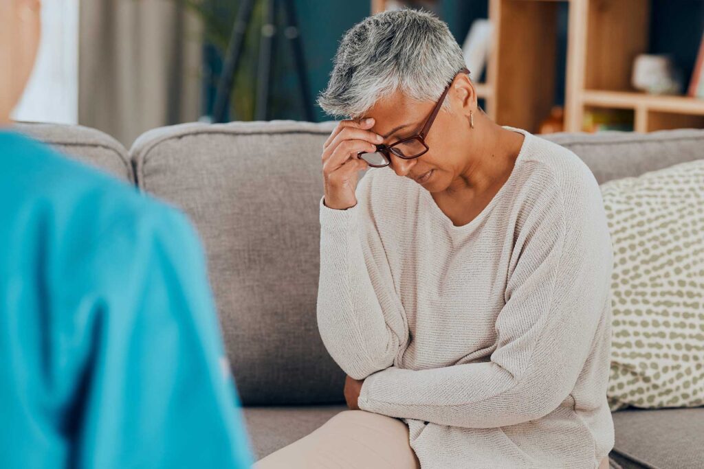 an older person presses their fingertips to their temple as they learn about moral inventory and recovery