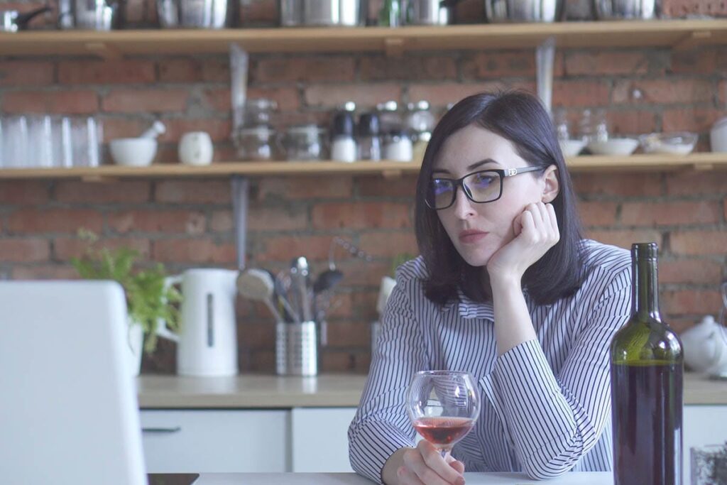 a person drinks a glass of wine while thinking about the Dangers of Wine Culture