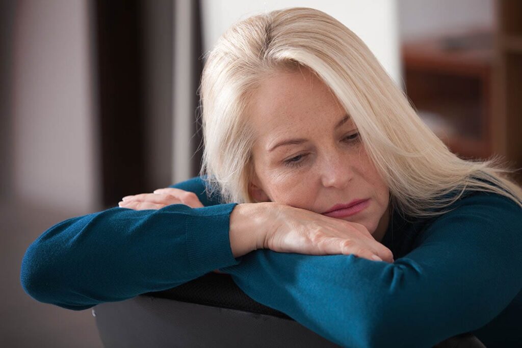 an older woman leans against a chair and thinks about substance abuse in older adults