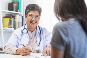 a friendly smiling doctor talks to a patient in an intensive outpatient program