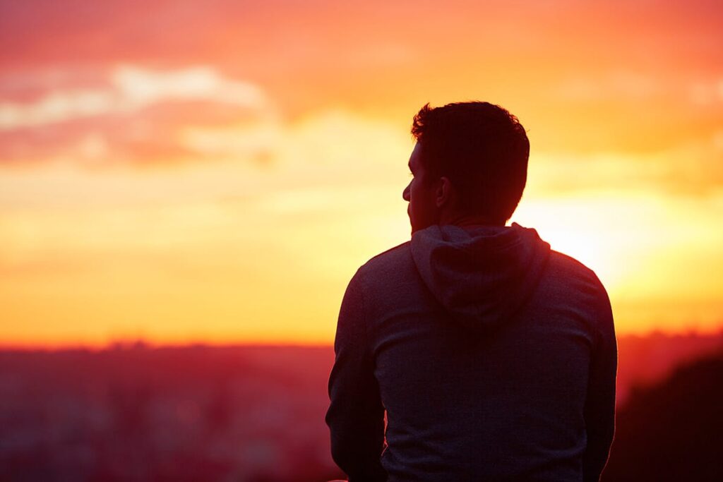 a person watches the sunrise as they ponder the connection between gastric bypass and alcoholism