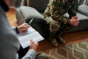 a therapist and a person in army fatigues talk during a PTSD Treatment Program