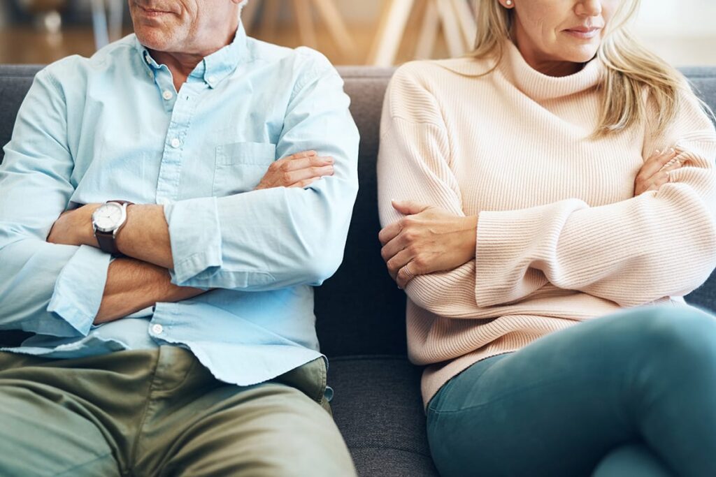 Couple sits next to one another with arms folded after learning how Adderall impacts relationships