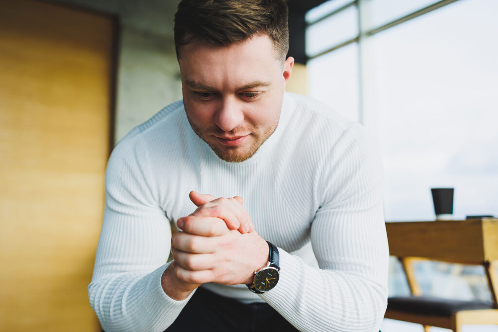 Man holds his hands together and wonders how do autism and addiction interact