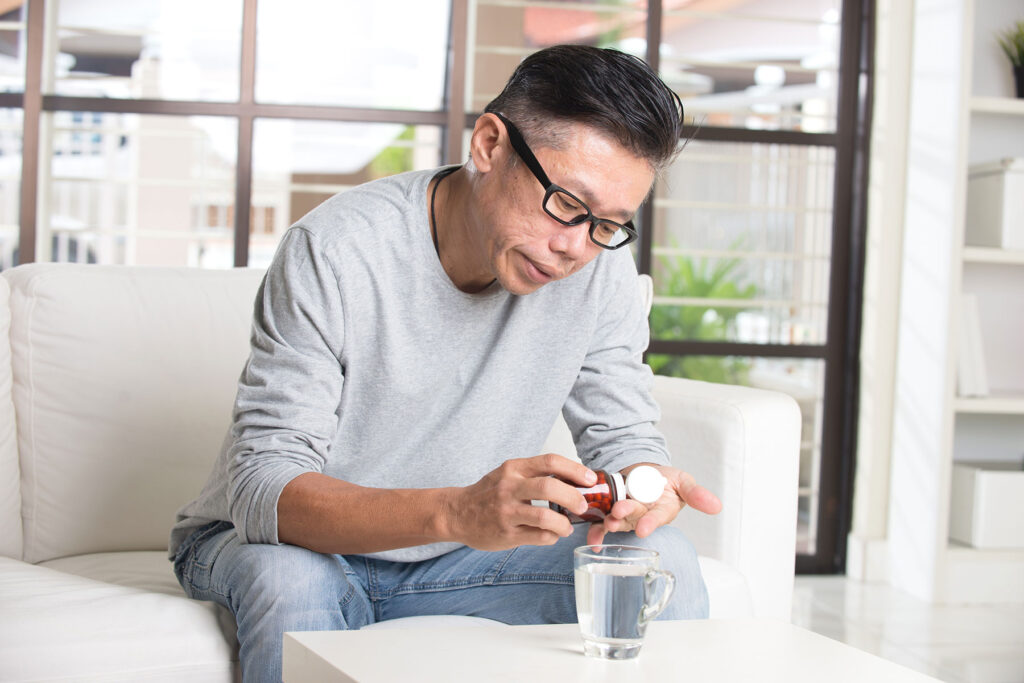 Man takes a Lunesta pill out of bottle, while pondering, "is Lunesta addictive?"